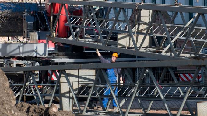 A construction worker surrounded by steel girders (opens enlarged image)