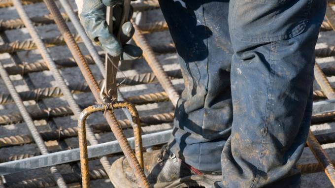 Beine und Hände eines Bauarbeiters, der an einer Stahlkonstruktion arbeitet (öffnet Vergrößerung des Bildes)