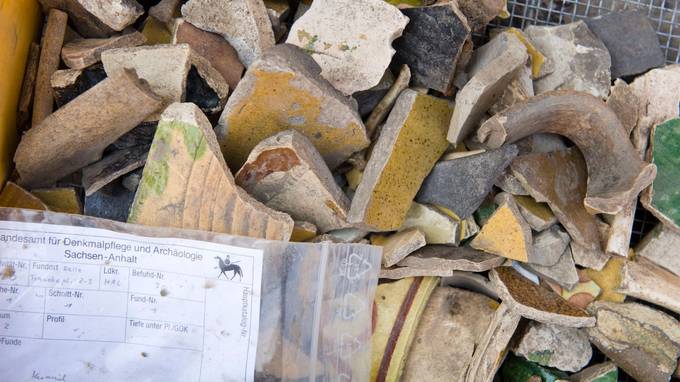 Various shards of pottery, on it a sheet with the inscription "Saxony-Anhalt State Office for the Preservation of Monuments and Archaeology" (opens enlarged image)