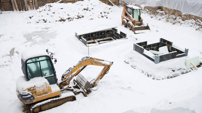 Mit Schnee bedeckte Baustelle, auf der zwei eingeschneite Baufahrzeuge stehen (öffnet Vergrößerung des Bildes)