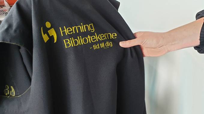 Hand hält Weste mit Aufschrift "Herning Bibliotekerne" (öffnet Vergrößerung des Bildes)