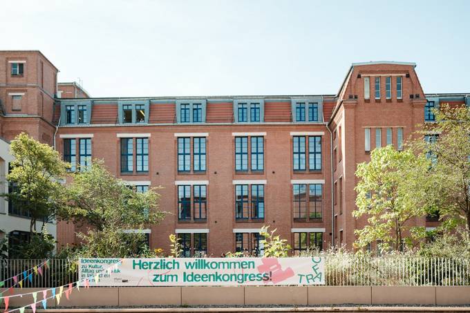 Gebäudeansicht mit Textbanner "Herzlichen Willkommen zum Ideenkongress"
