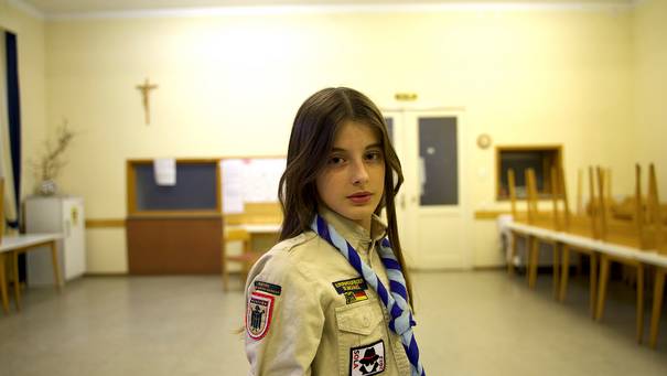 13-jähriges Mädchen mit Uniform in einem Saal