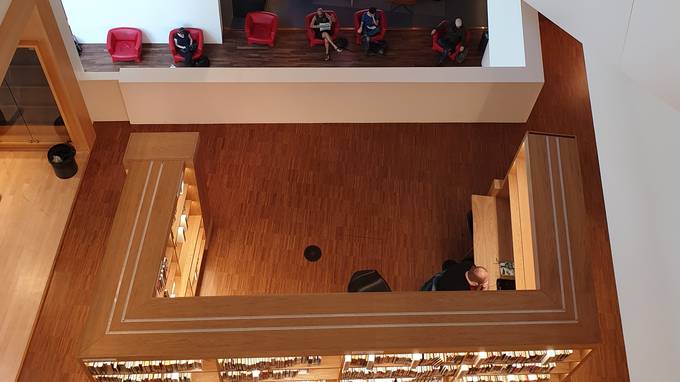 Vogelperspektive auf hölzernen Raum mit Bücherregal und Café hinter Trennwand (öffnet Vergrößerung des Bildes)